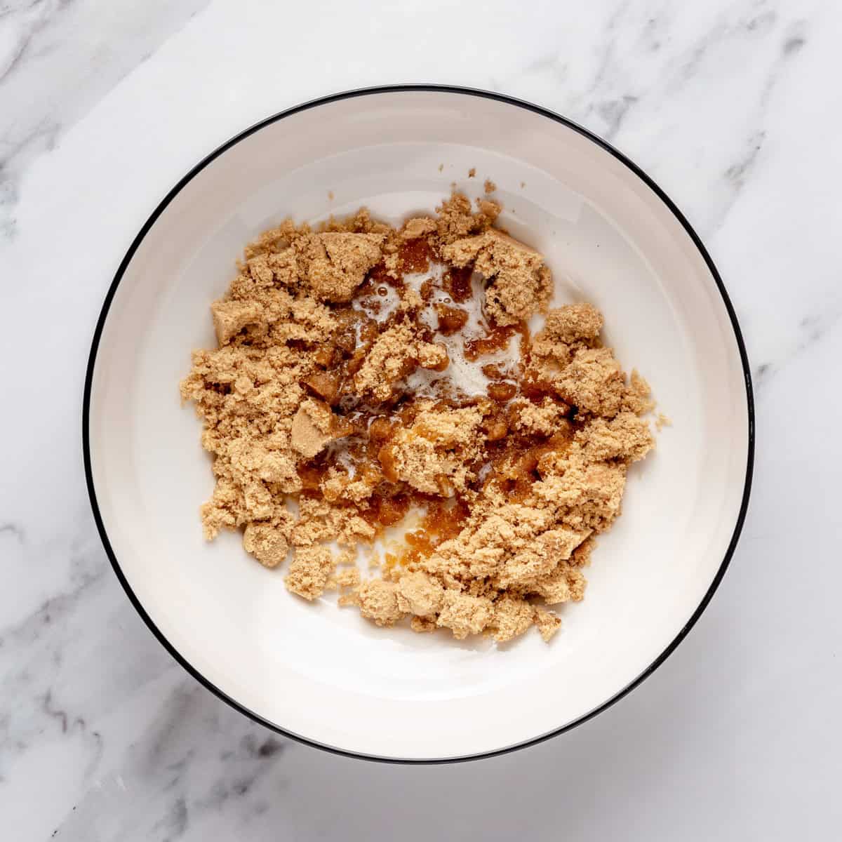 Brown sugar and melted butter in a bowl before mixing.