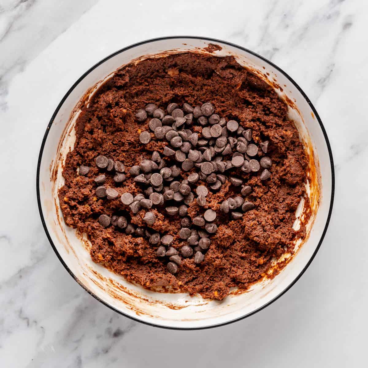 Chocolate chips added to brownie batter before mixing.