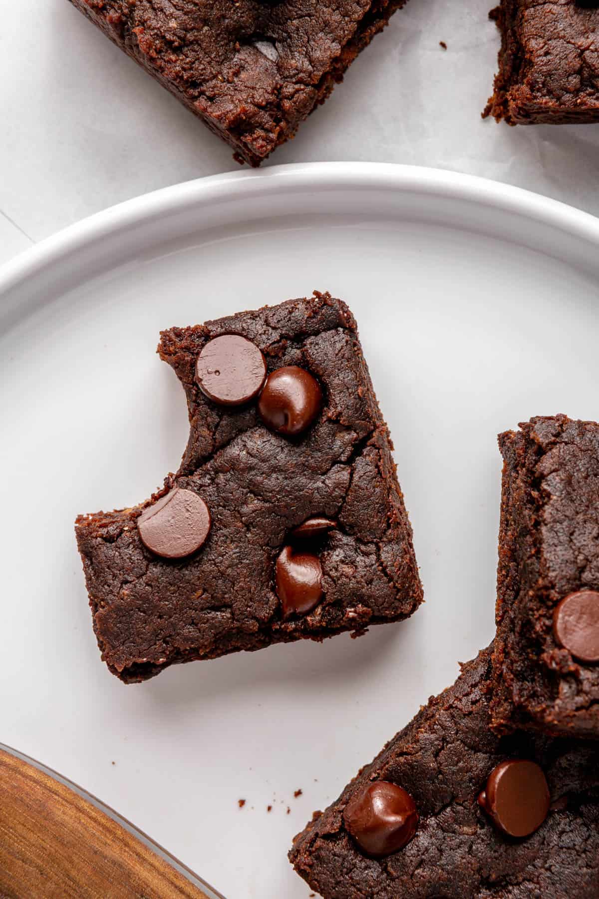 Close up of a sweet potato brown with chocolate chips on a plate with a bite taken out.