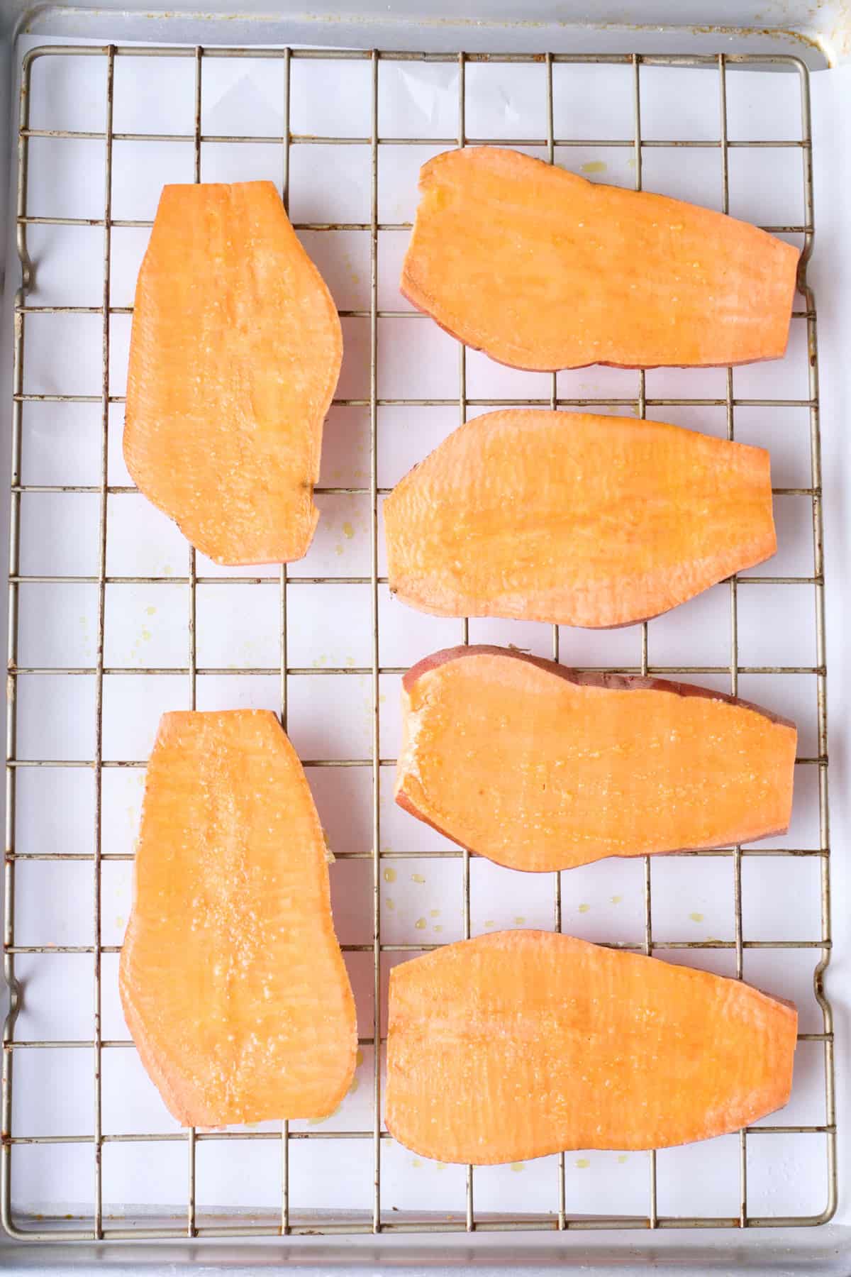 Sweet potato planks on a wire rack before roasting.