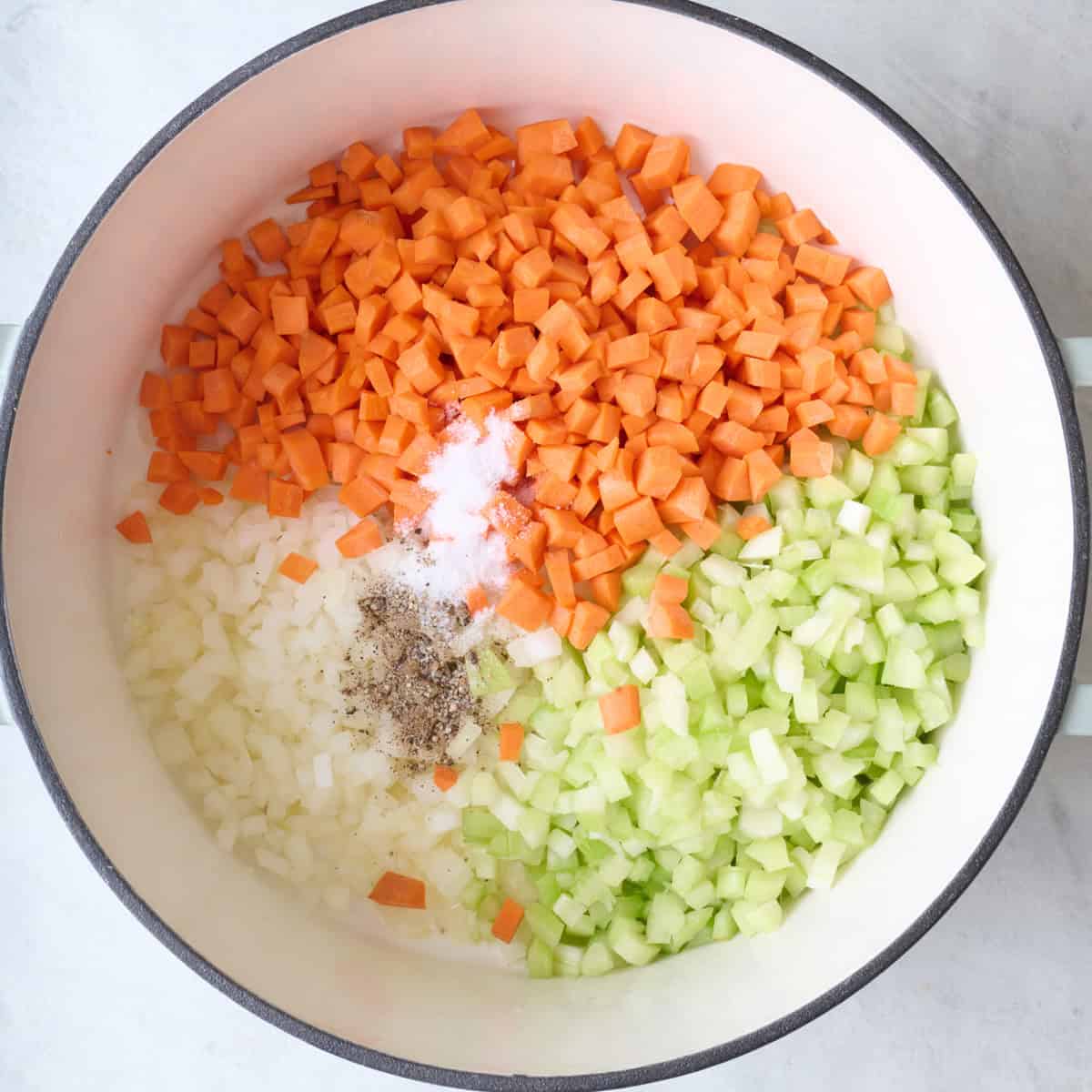 Chopped veggies in a pot with salt and pepper.