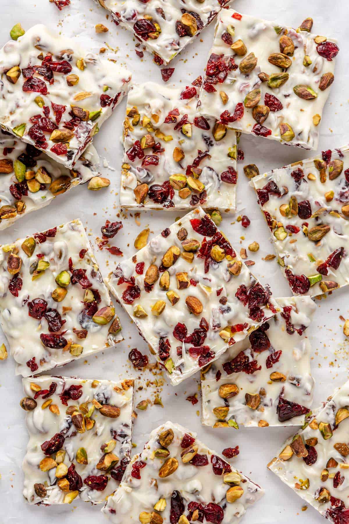 White chocolate bark broken into square pieces on parchment paper.