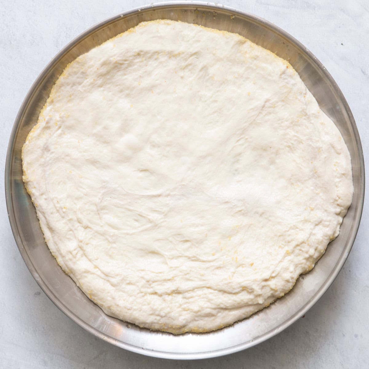 Dough on pan stretched into circle.