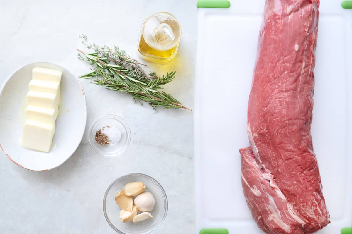 Ingredients for recipe: butter, fresh herbs, salt and pepper, garlic, oil, and a whole beef tenderloin roast.