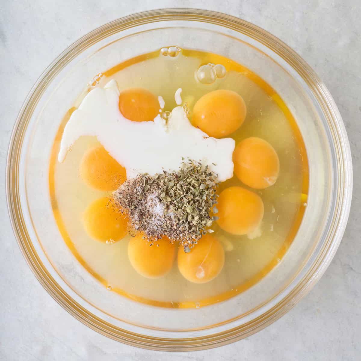 Eggs, milk, and seasonings in a bowl before whisking.