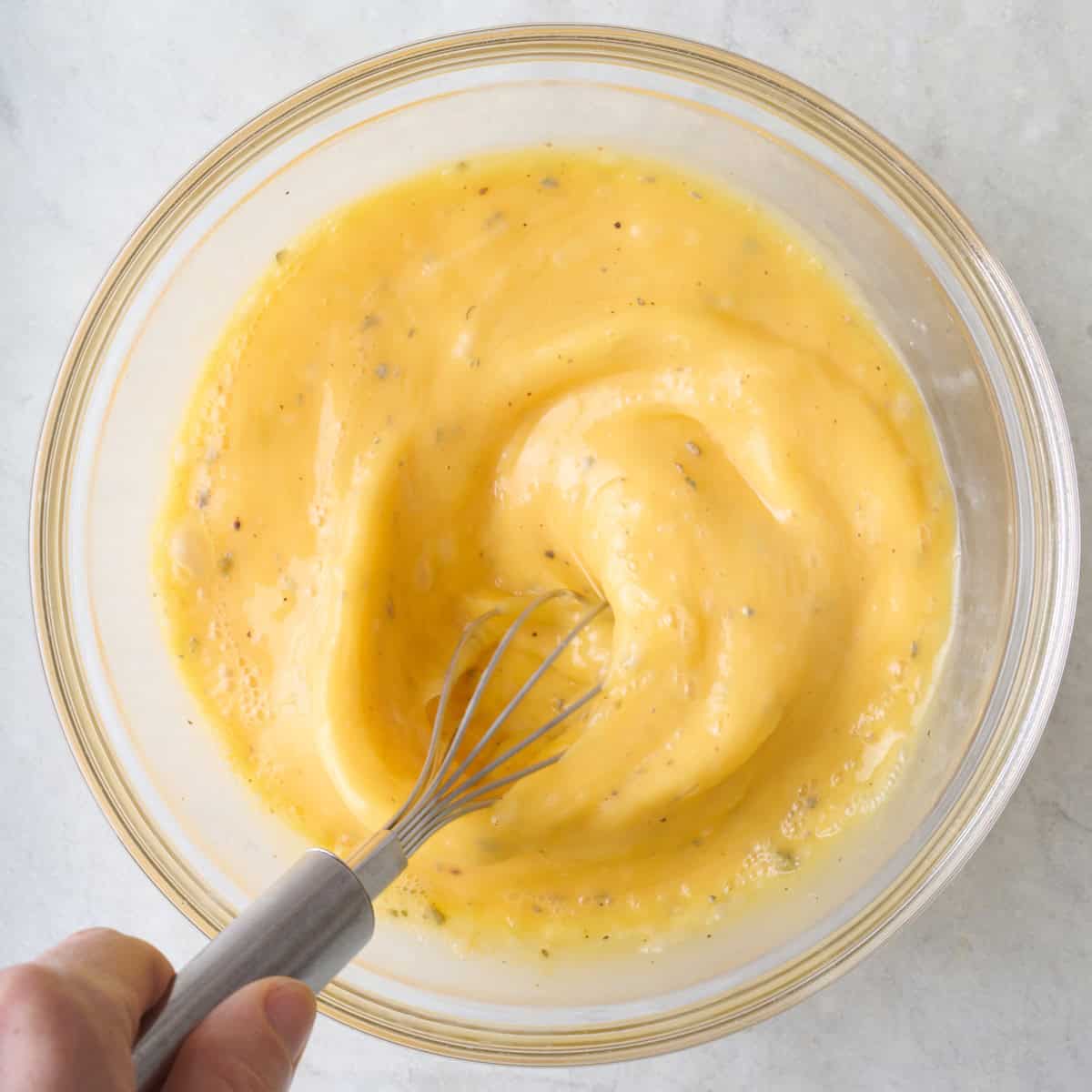 Egg mixture being whisked in a bowl.