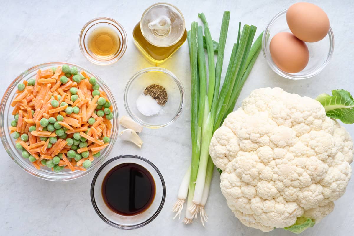 Ingredients for recipe: frozen peas and carrots, sesame oil, avocado oil, salt and pepper, garlic, soy sauce, green onions, cauliflower, and eggs.