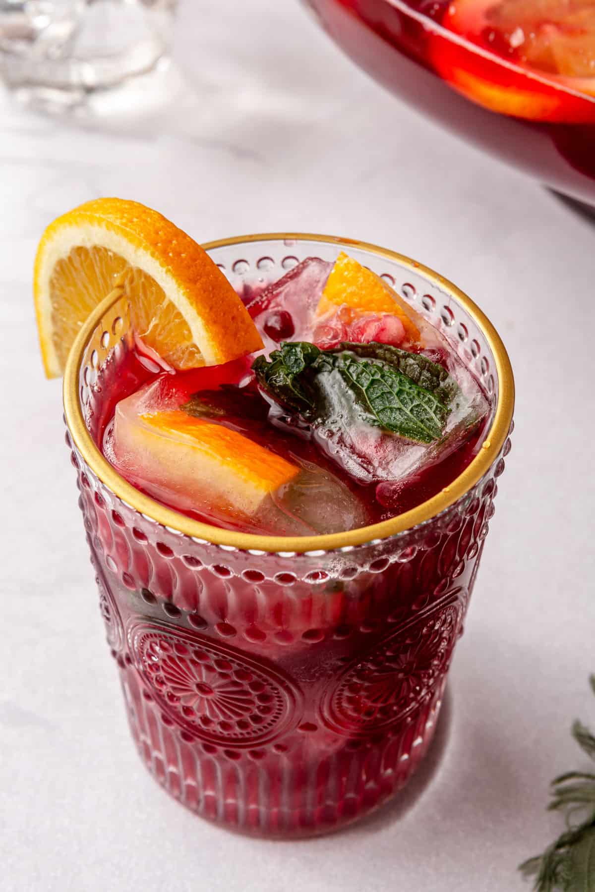 Glass of Christmas punch in a glass with festive ice cubes.