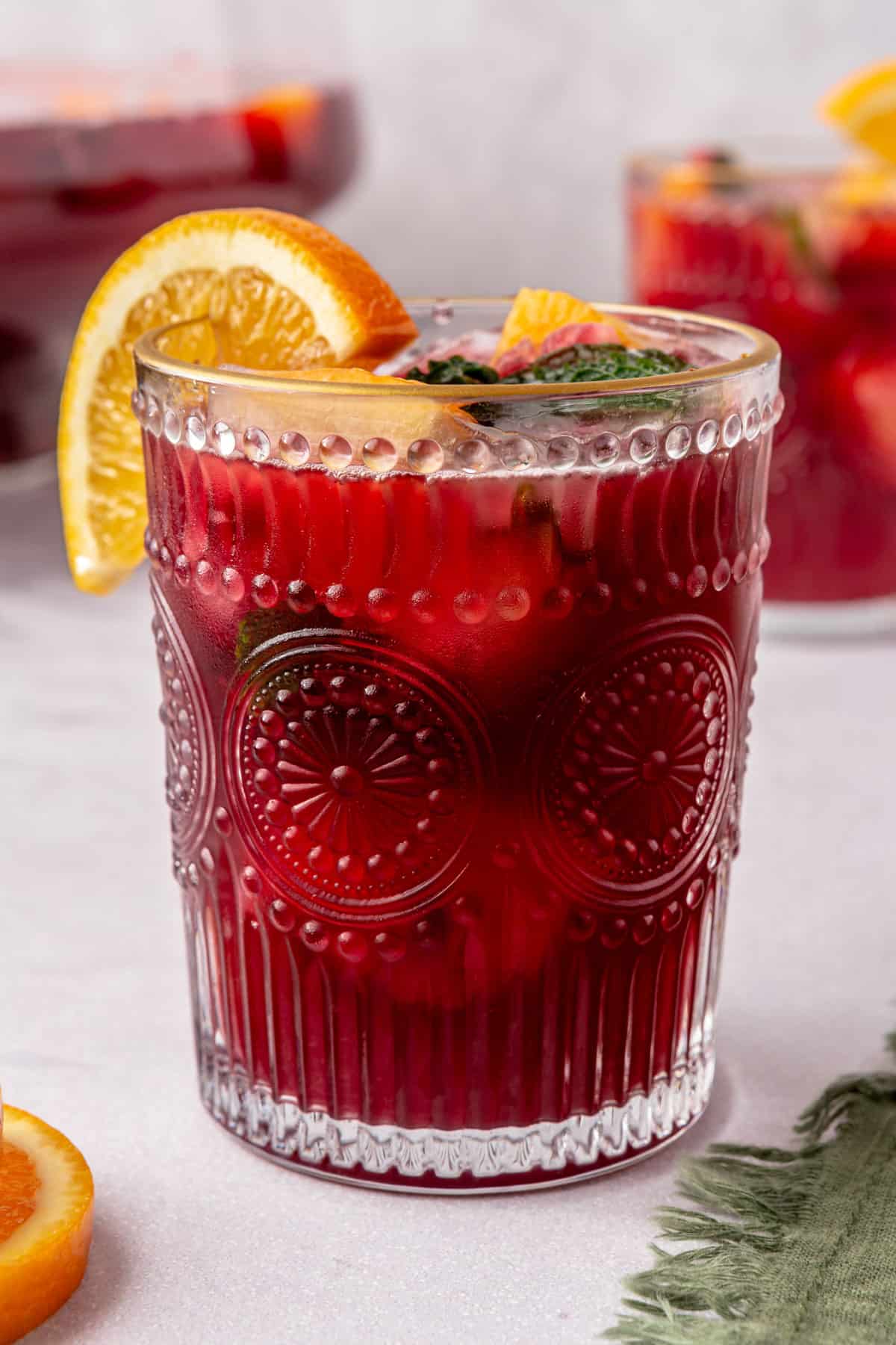 Christmas punch in a glass with an orange slice on the rim.