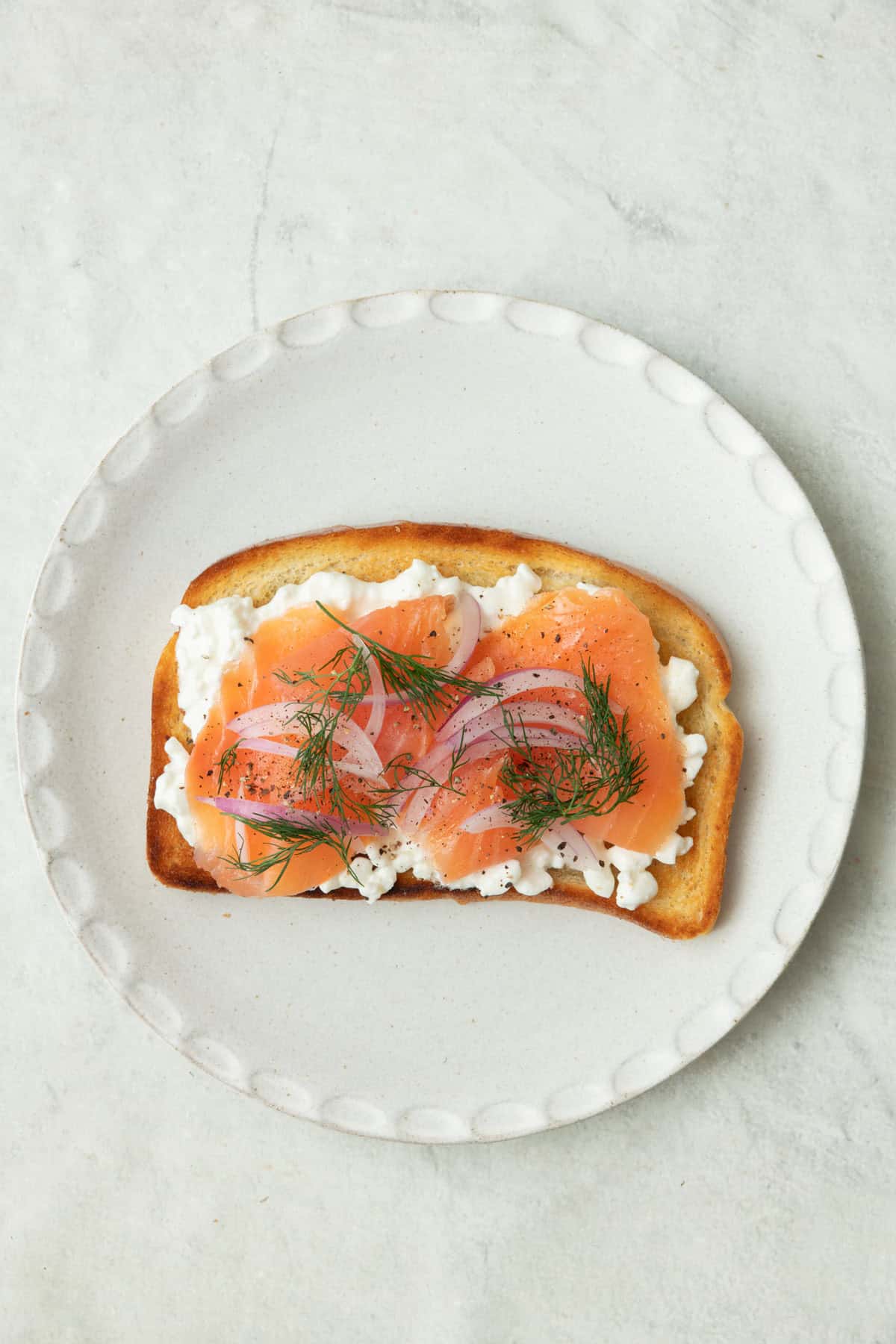 Toast with cottage cheese, smoked salmon, onions, and dill.