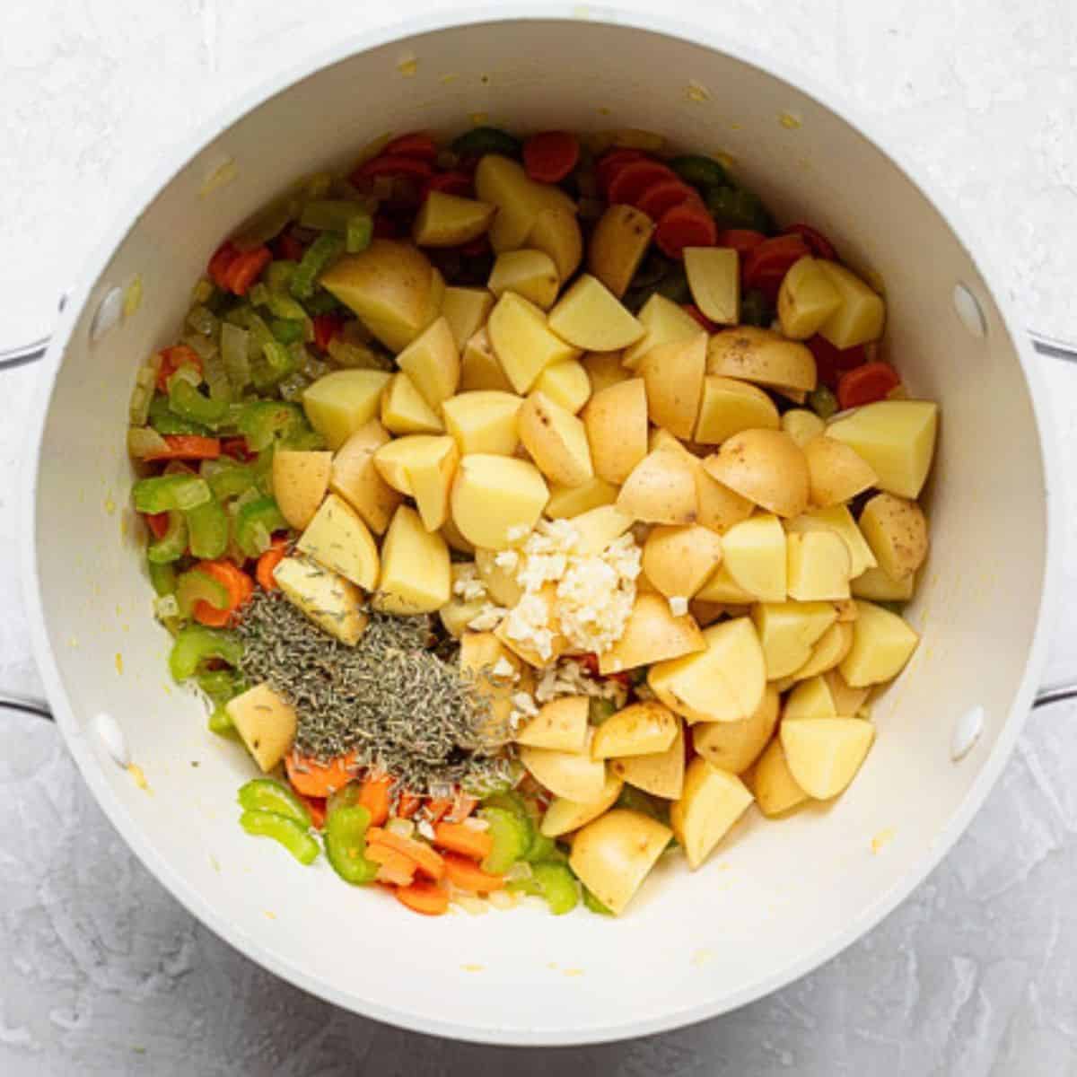 Potatoes, garlic, and herbs added to cooked veggies.