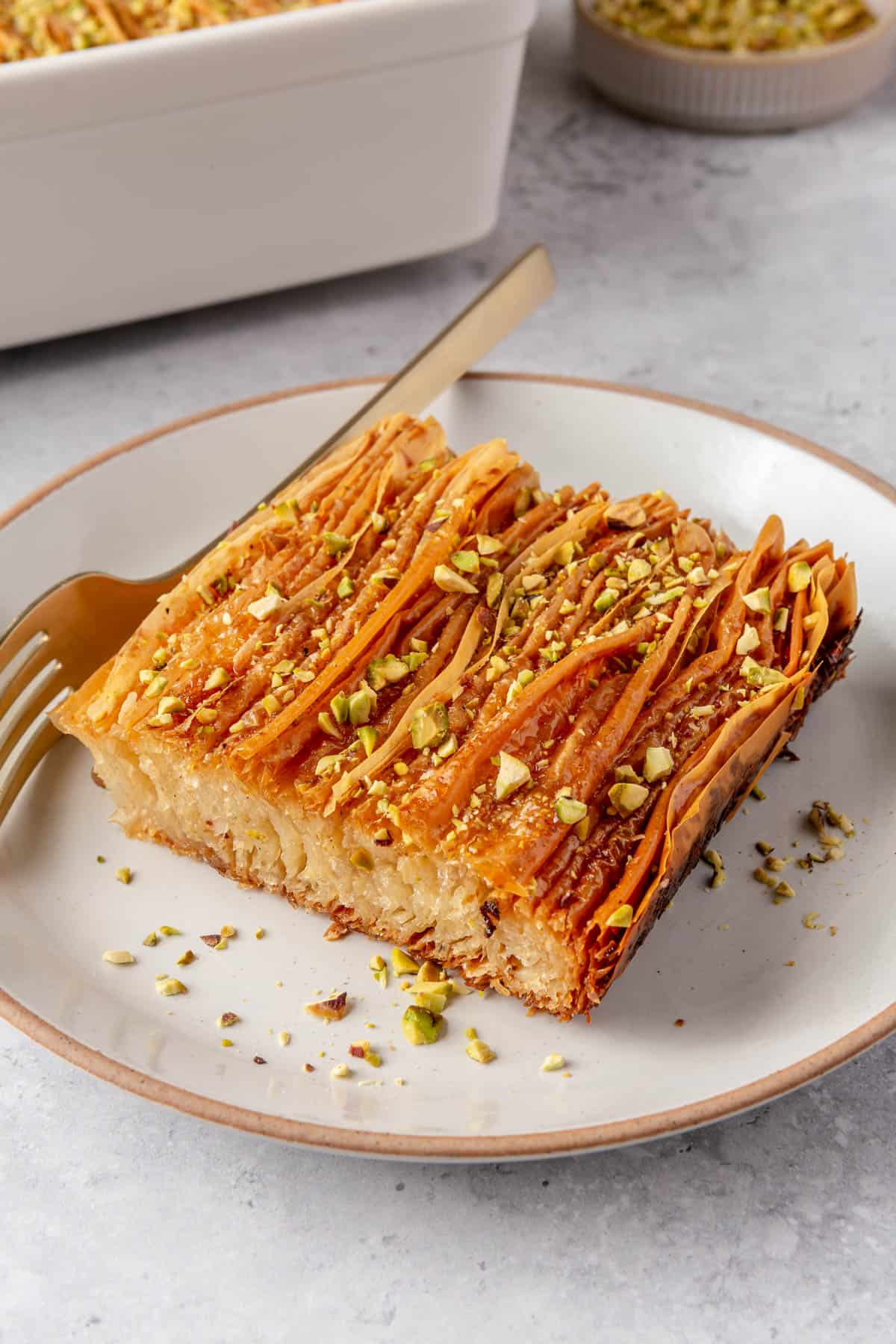 Pistachio crinkle cake slice on a plate showing the inside texture.