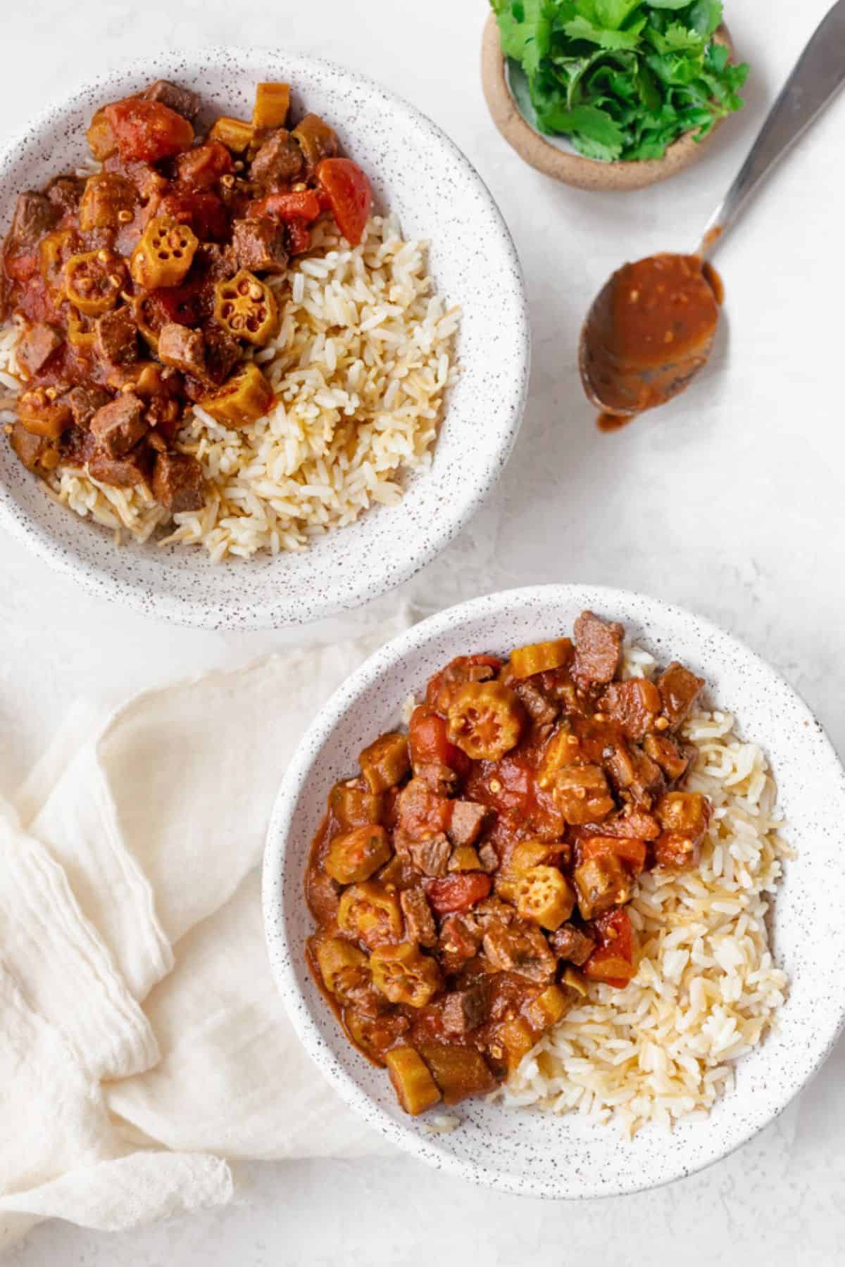 Two bowls of okra stew with beef and rice.