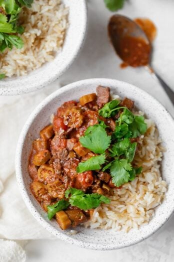 Okra stew with beef in a bowl over fluffy rice.