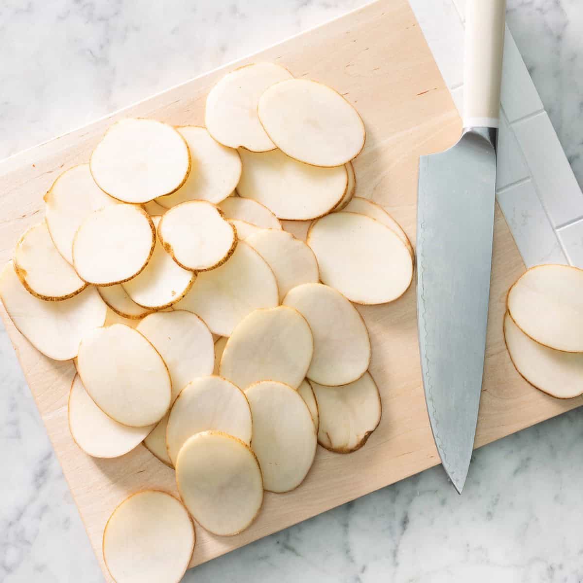 Sliced potatoes on a cutting board.