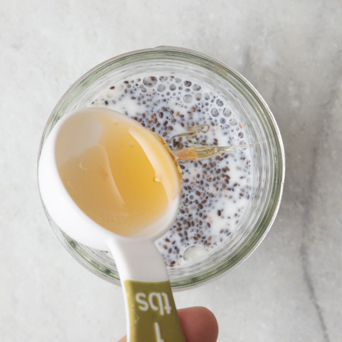 Honey being added to jar.