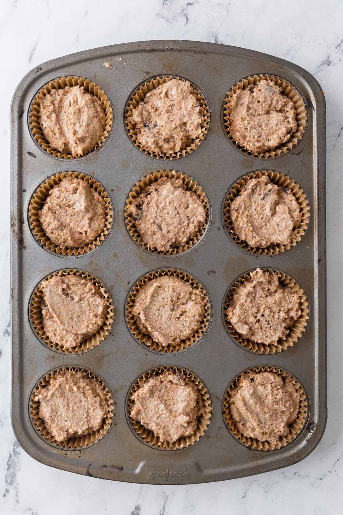 Batter added to muffin pan before baking.