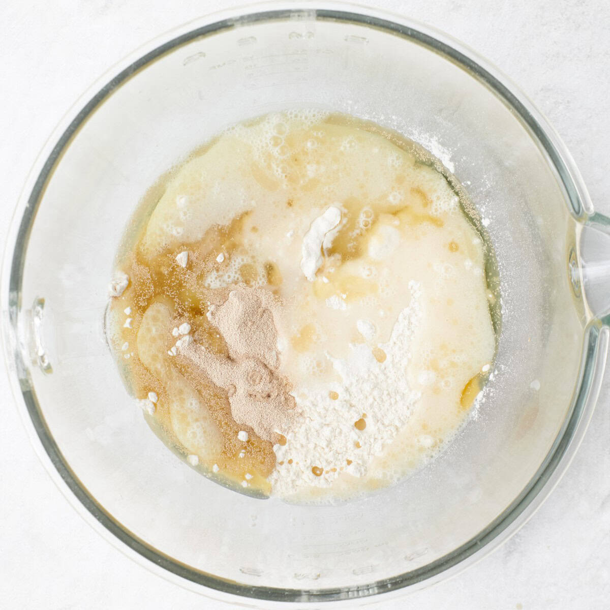 Water, yeast, salt, flour and oil added to the bowl of a stand mixer before combining.