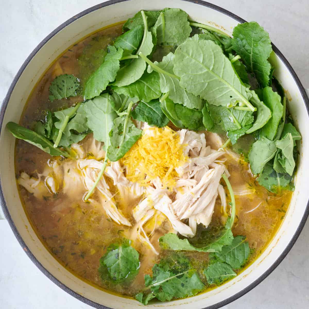 Chicken shredded and added back to pot with lemon zest, juice, and kale.