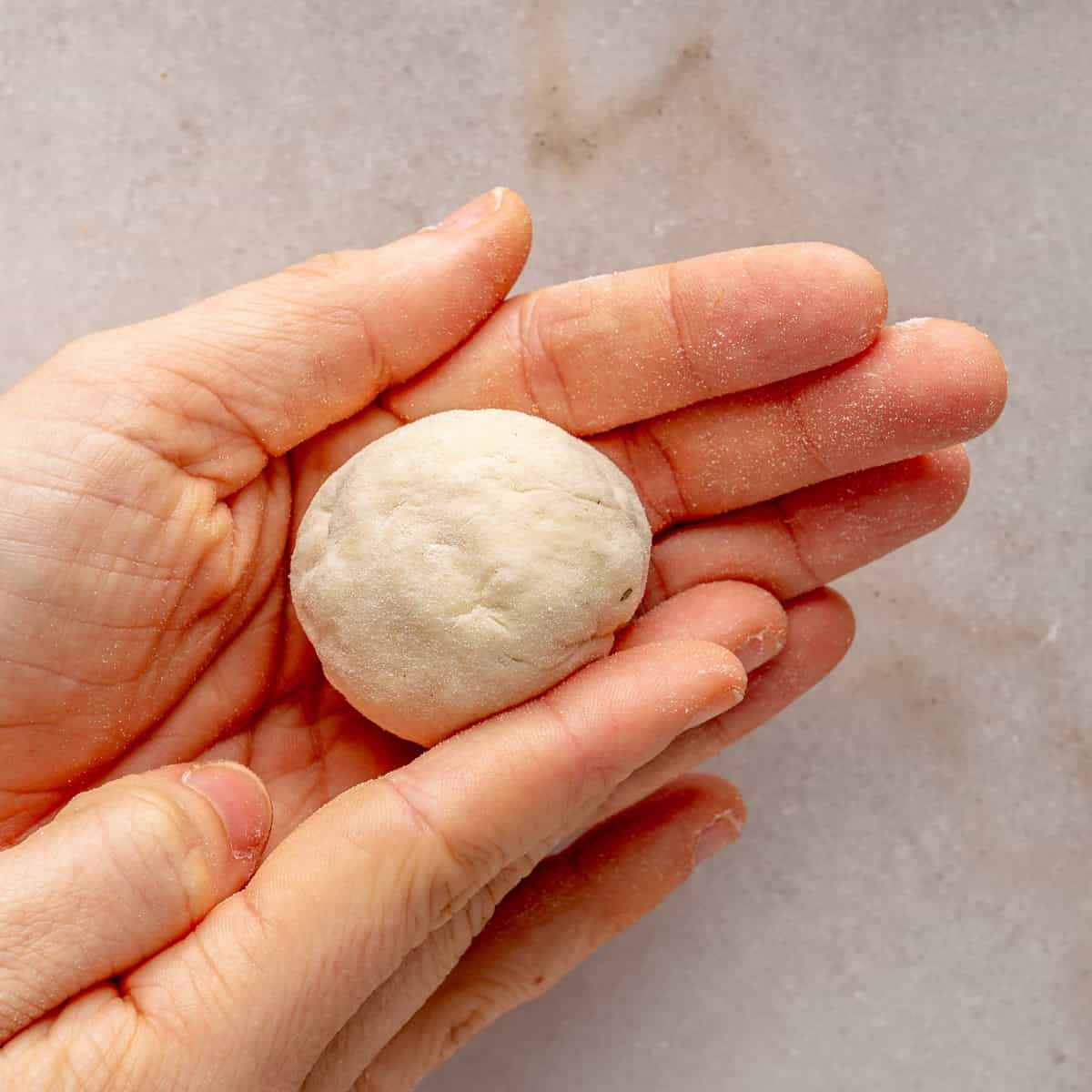 Rolling the dough ball in hands.