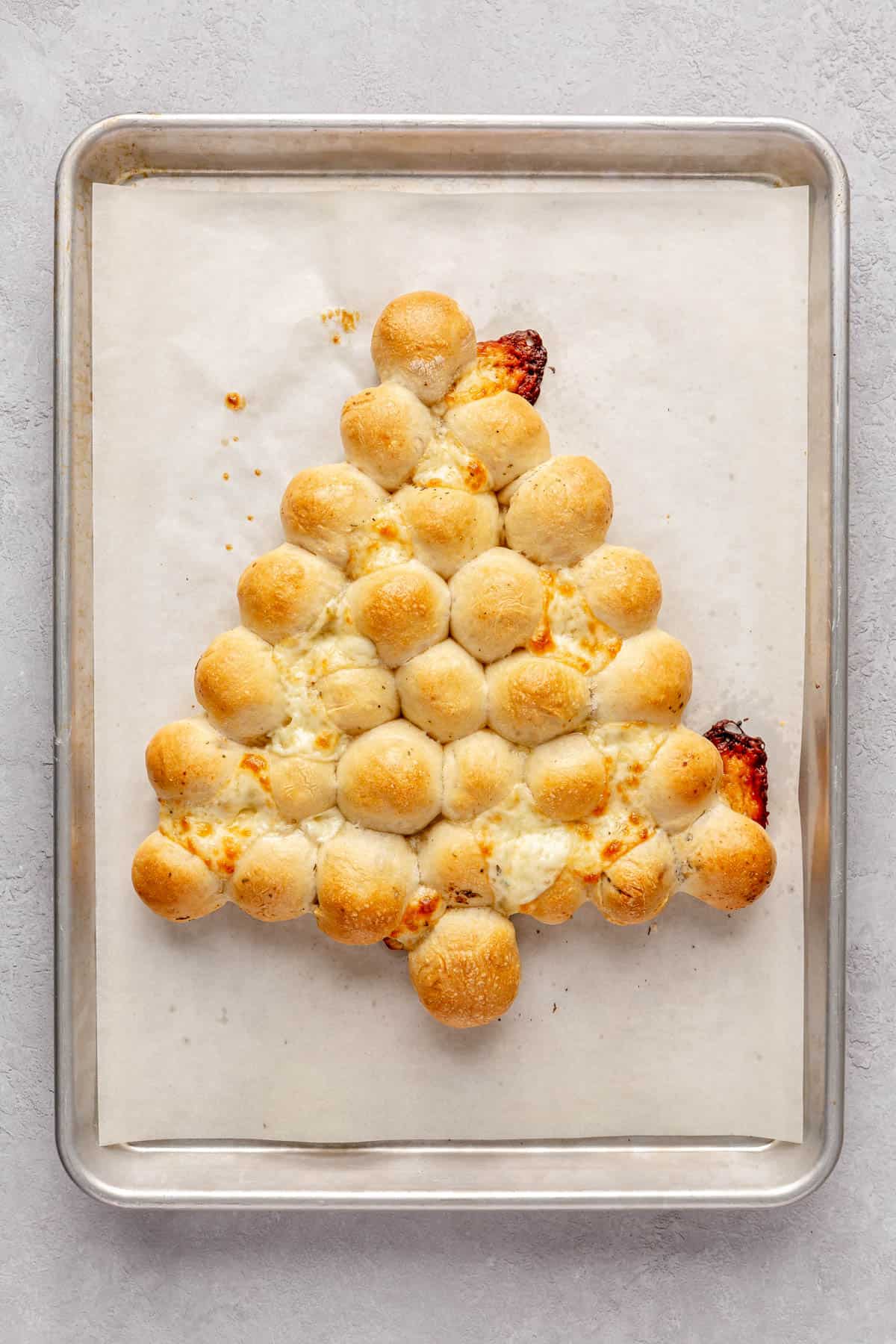 Cheese stuffed dough balls on a baking sheet after bakiing.