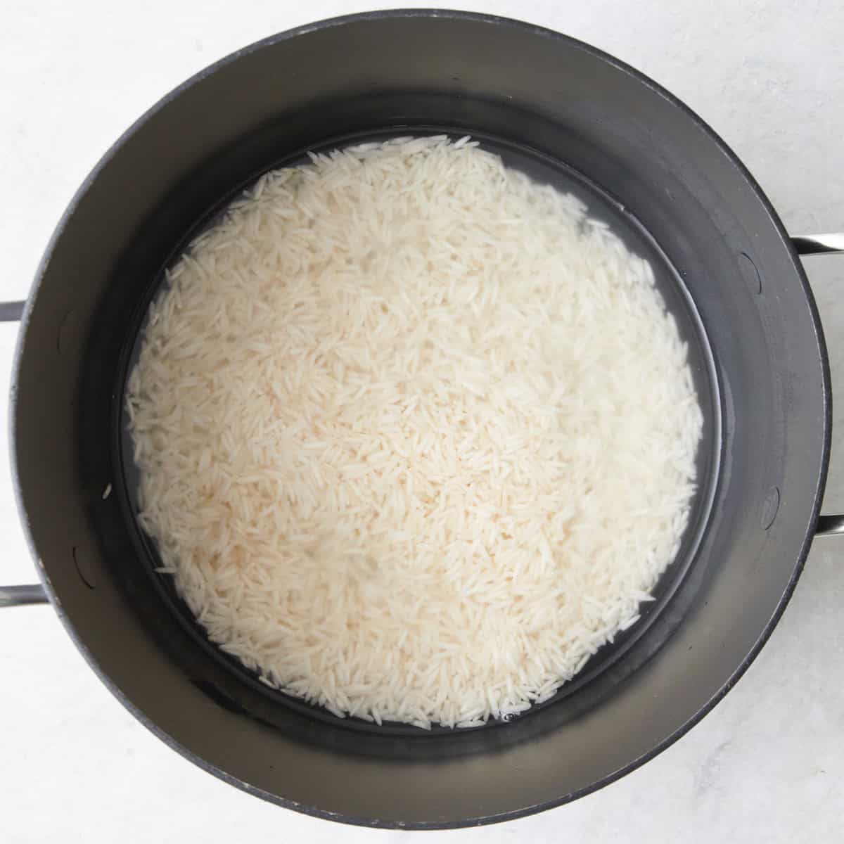 Rice in a pot of water before cooking.