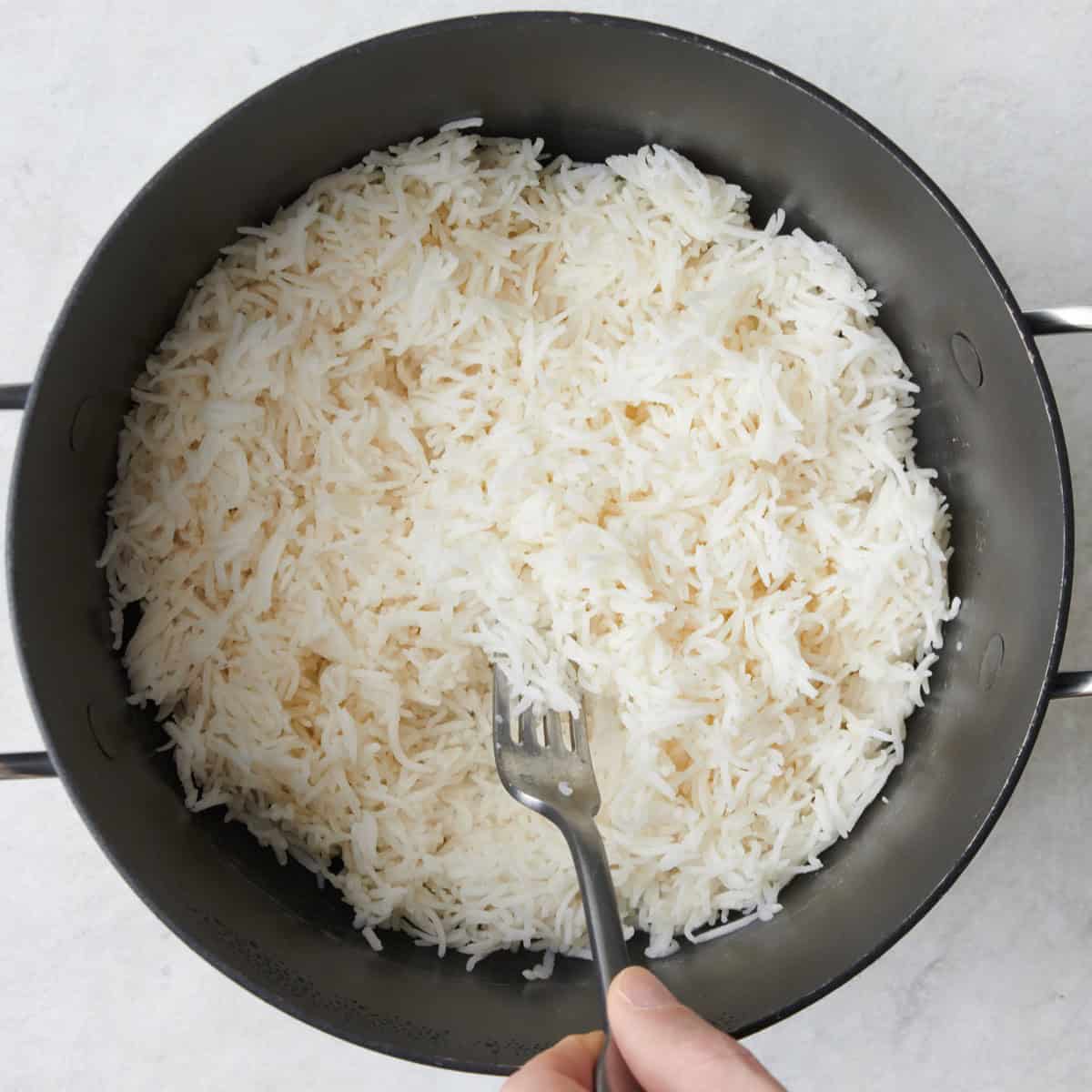 Fluffing rice with a fork.