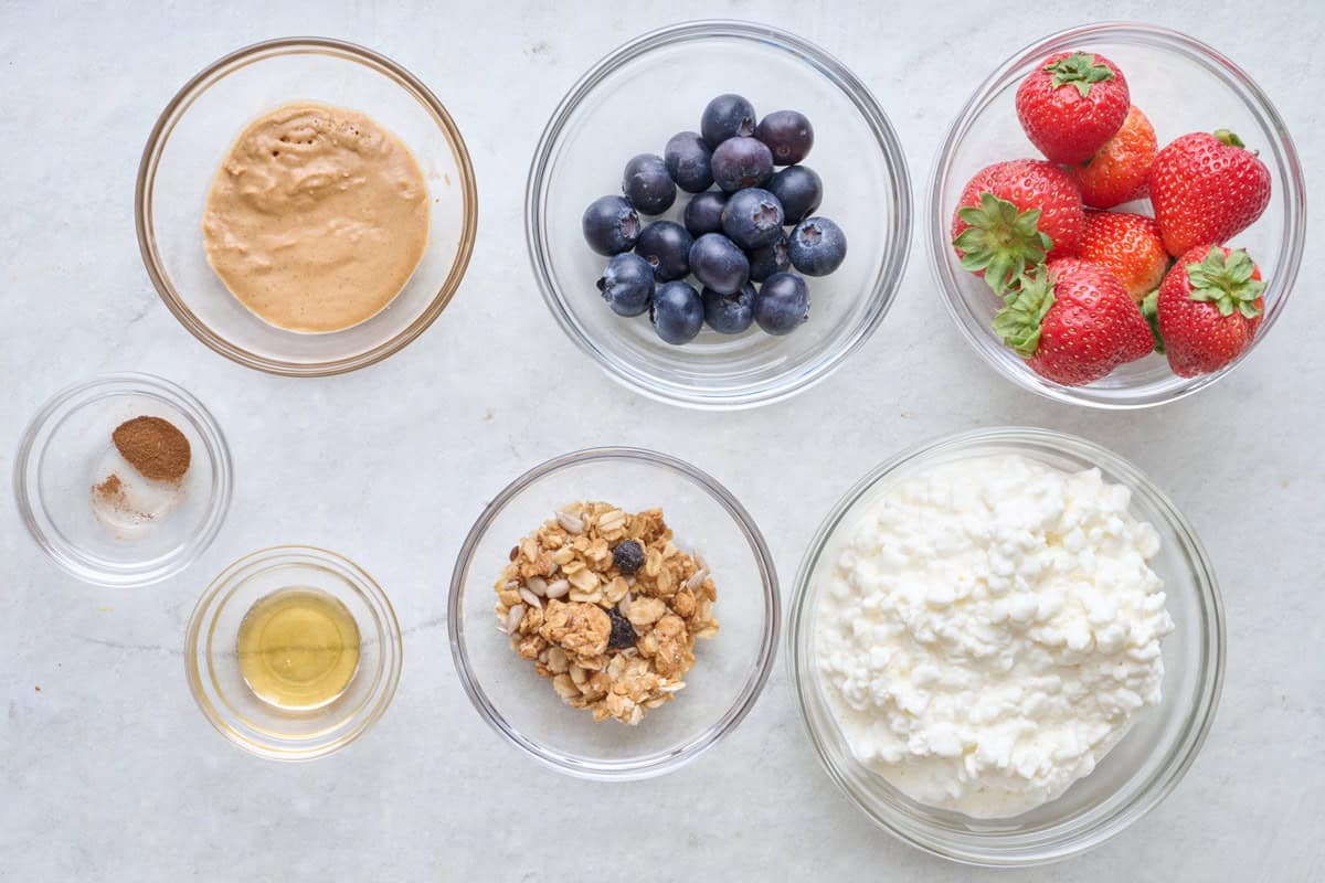 Ingredients for the sweet version of recipe: peanut butter, cinnamon, honey, blueberries, strawberries, granola, and cottage cheese.