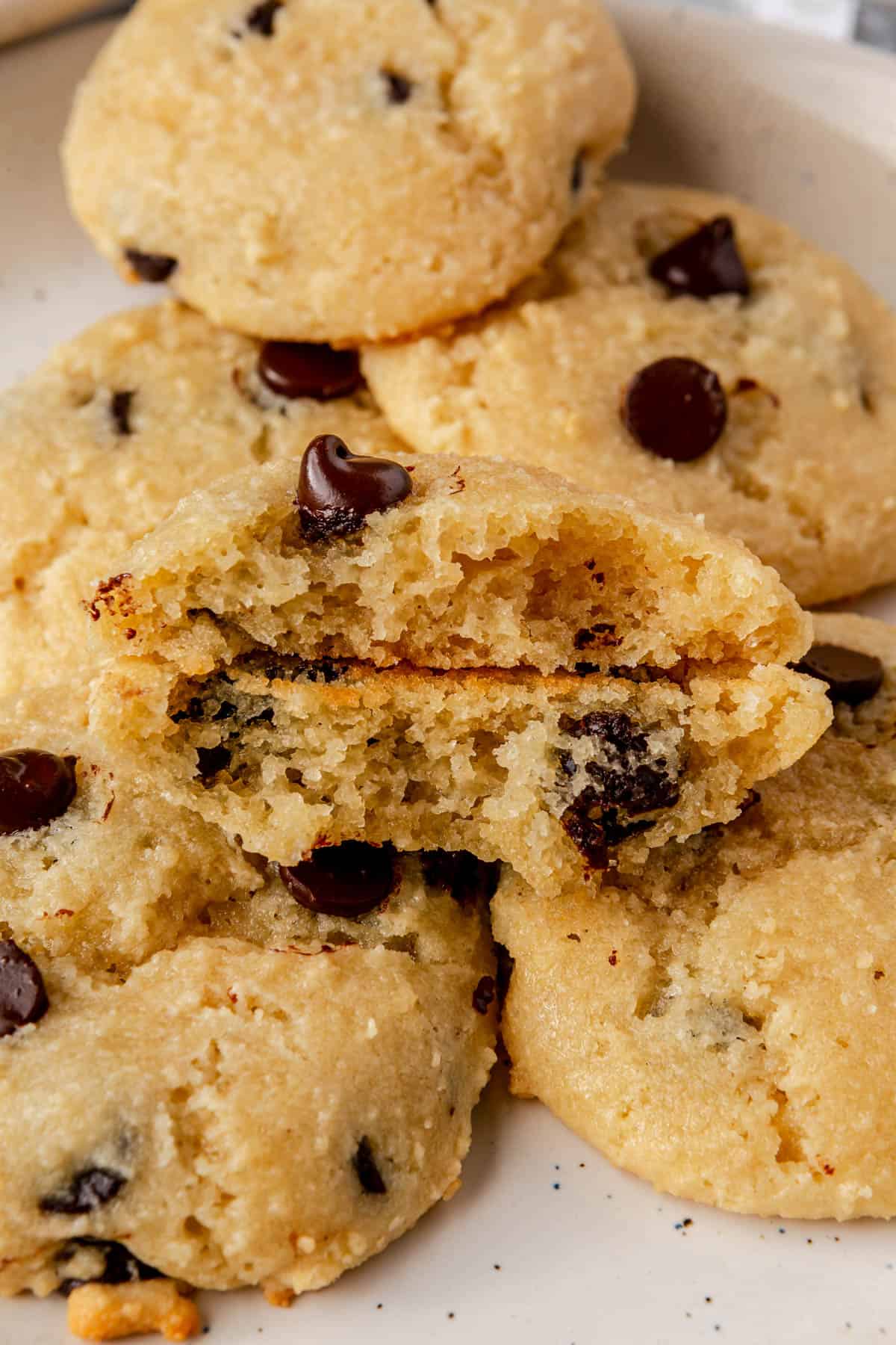 Almond flour cottage cheese cookies on a plate with one broken in half to show texture.