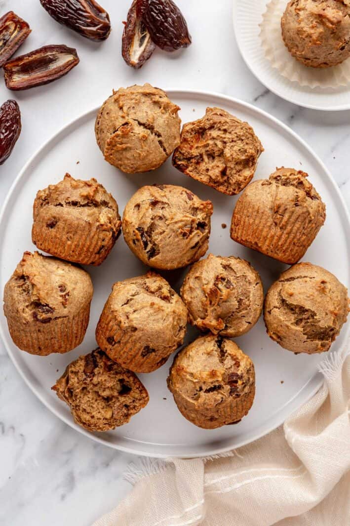 Date Muffins on a round platter with whole and halved dates nearby.