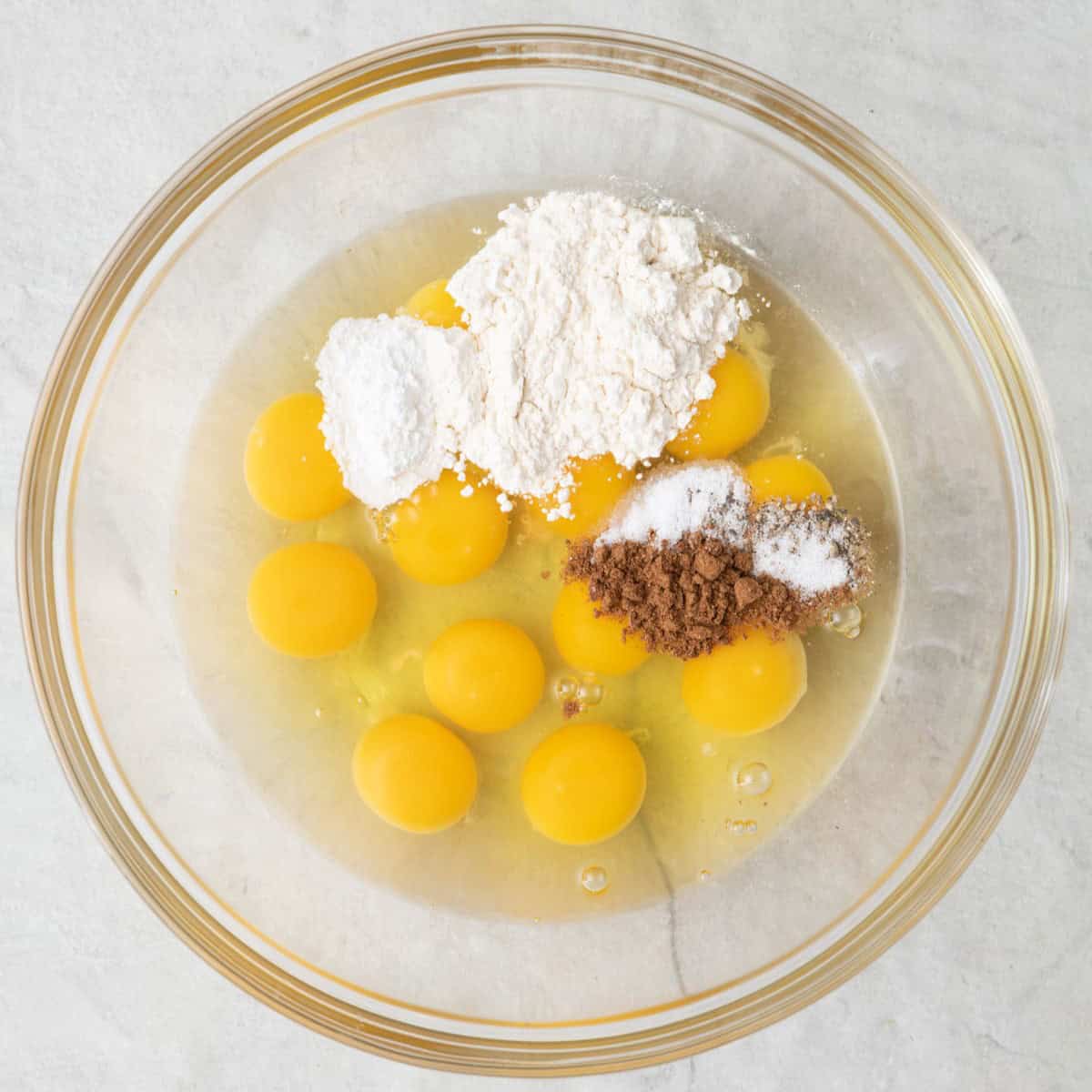 Eggs, flour, baking powder, and seasonings in a large bowl.