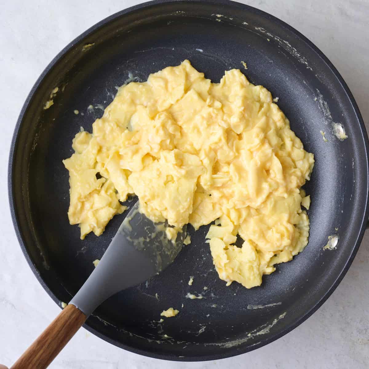 Spatula continuing to push eggs around the pan.