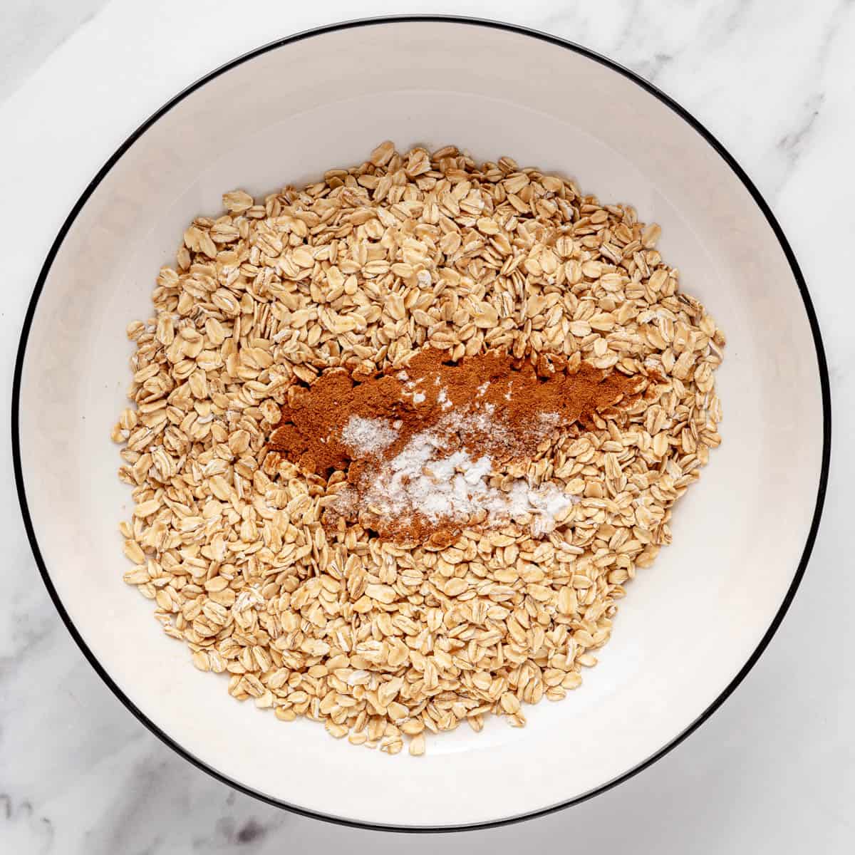 Oats, cinnamon, baking soda, and salt in a bowl before combining.