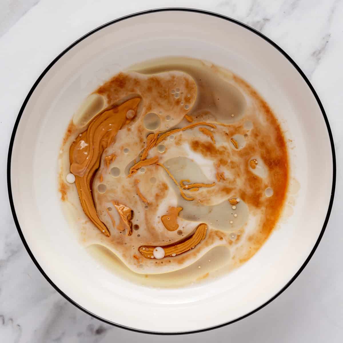 Maple syrup, peanut butter, oil and vanilla in a large bowl before mixing.