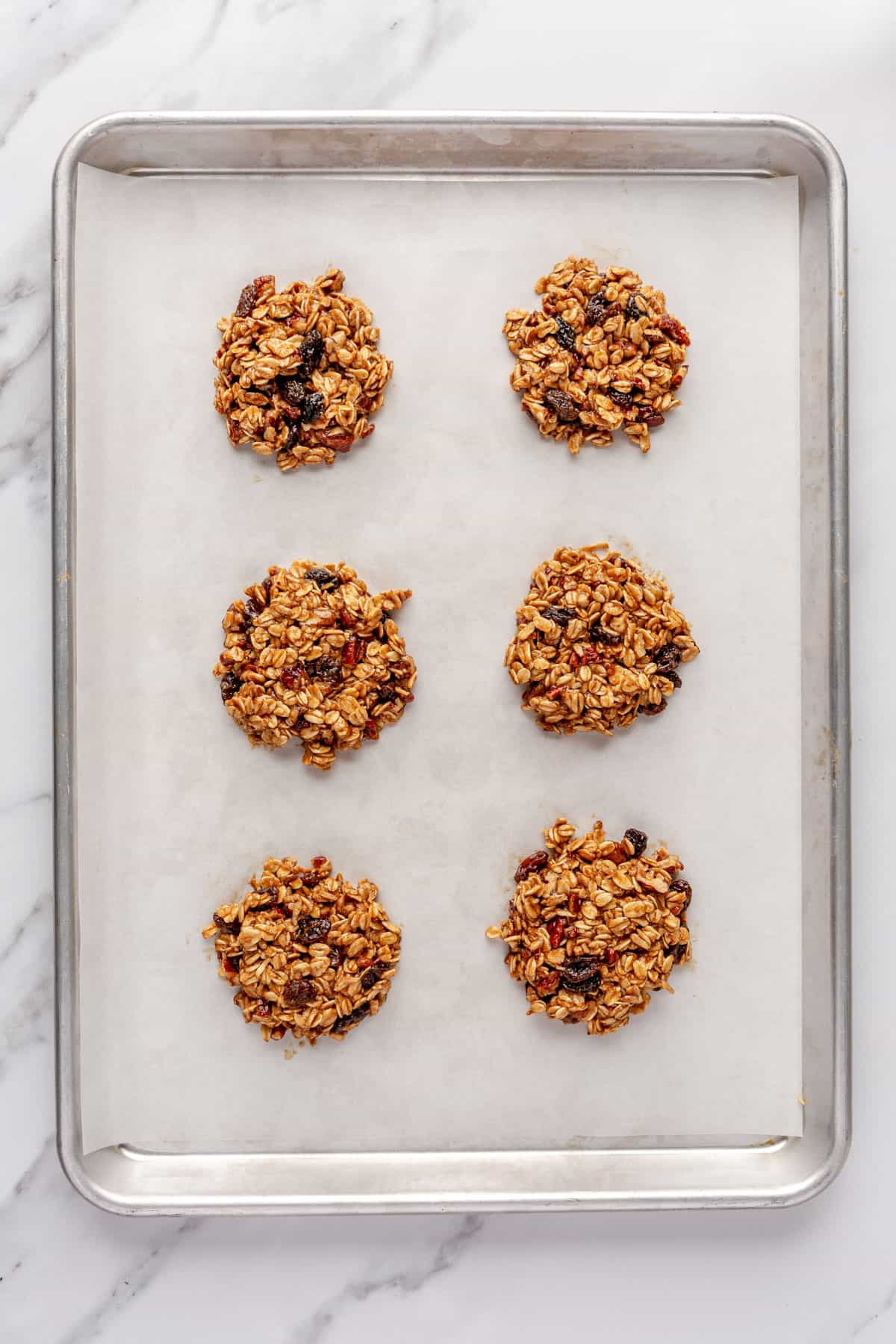 Cookie dough discs on a lined baking sheet.