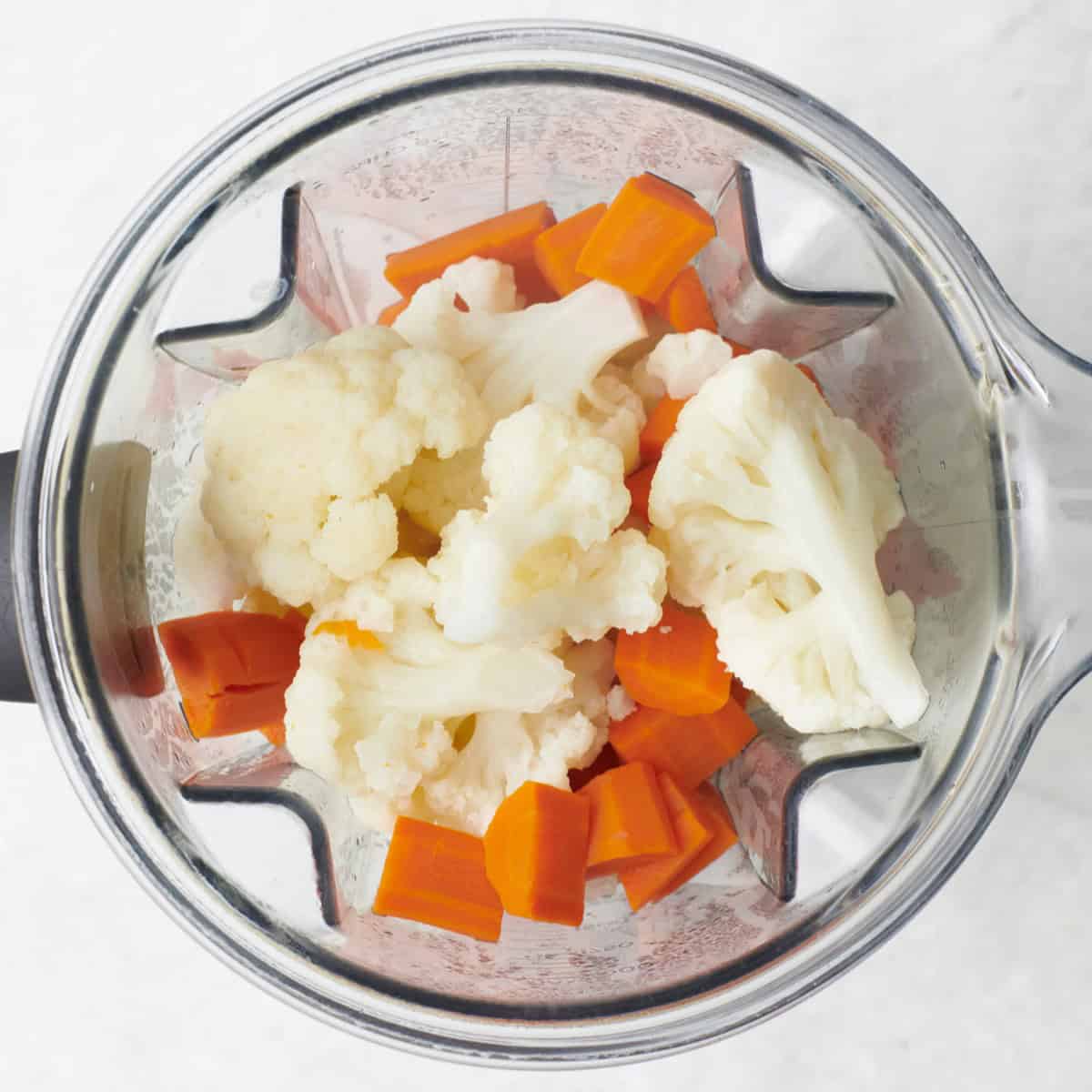 Veggies in a blender with cooking water before blendin.