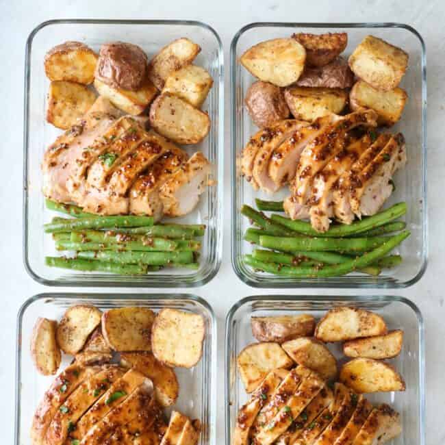 Honey mustard chicken with roasted potatoes and green beans in meal prep containers.