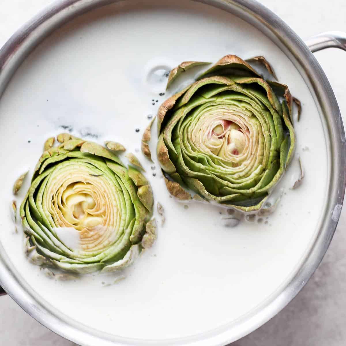 Artichoke in pot of water with lemon and flour mixture.