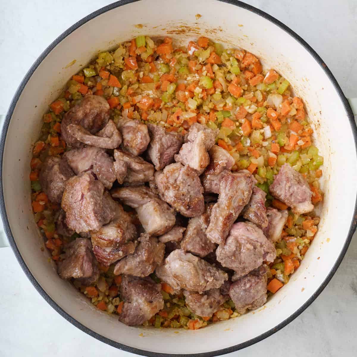 Cooked lamb pieces added back to pot with flour coated mirepoix.