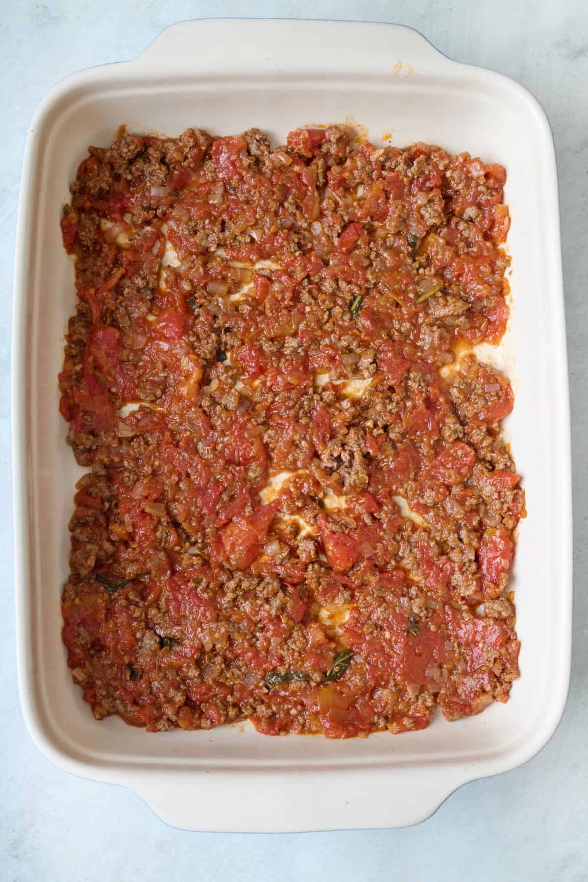 Meat sauce spread in baking dish.