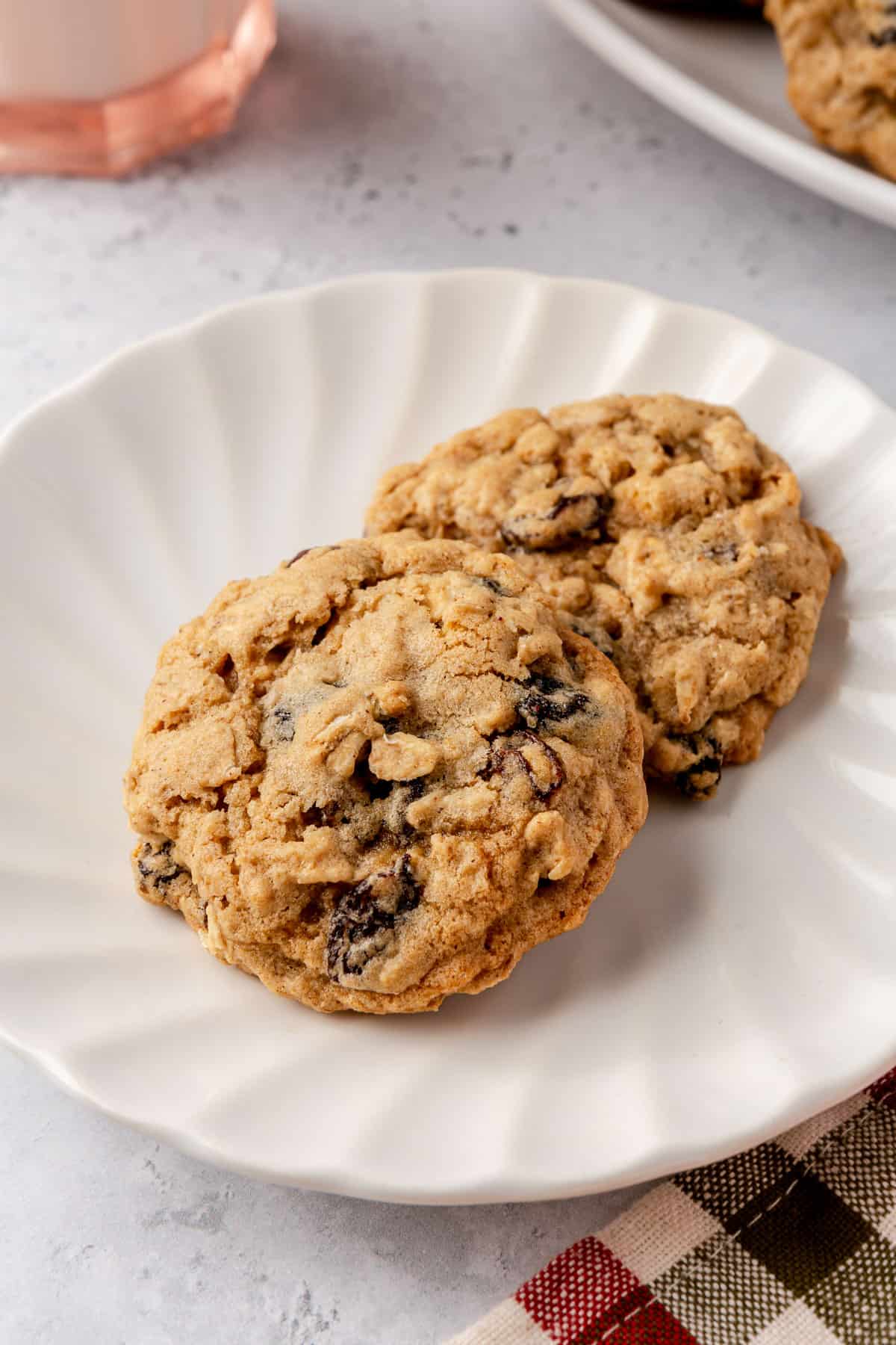 Two homemade classic oatmeal cookies on a small plate.