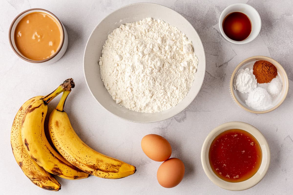 Ingredients for recipe before prepping: peanut butter, bananas, flour, vanilla, honey, baking powder, baking soda, salt and cinnamon.