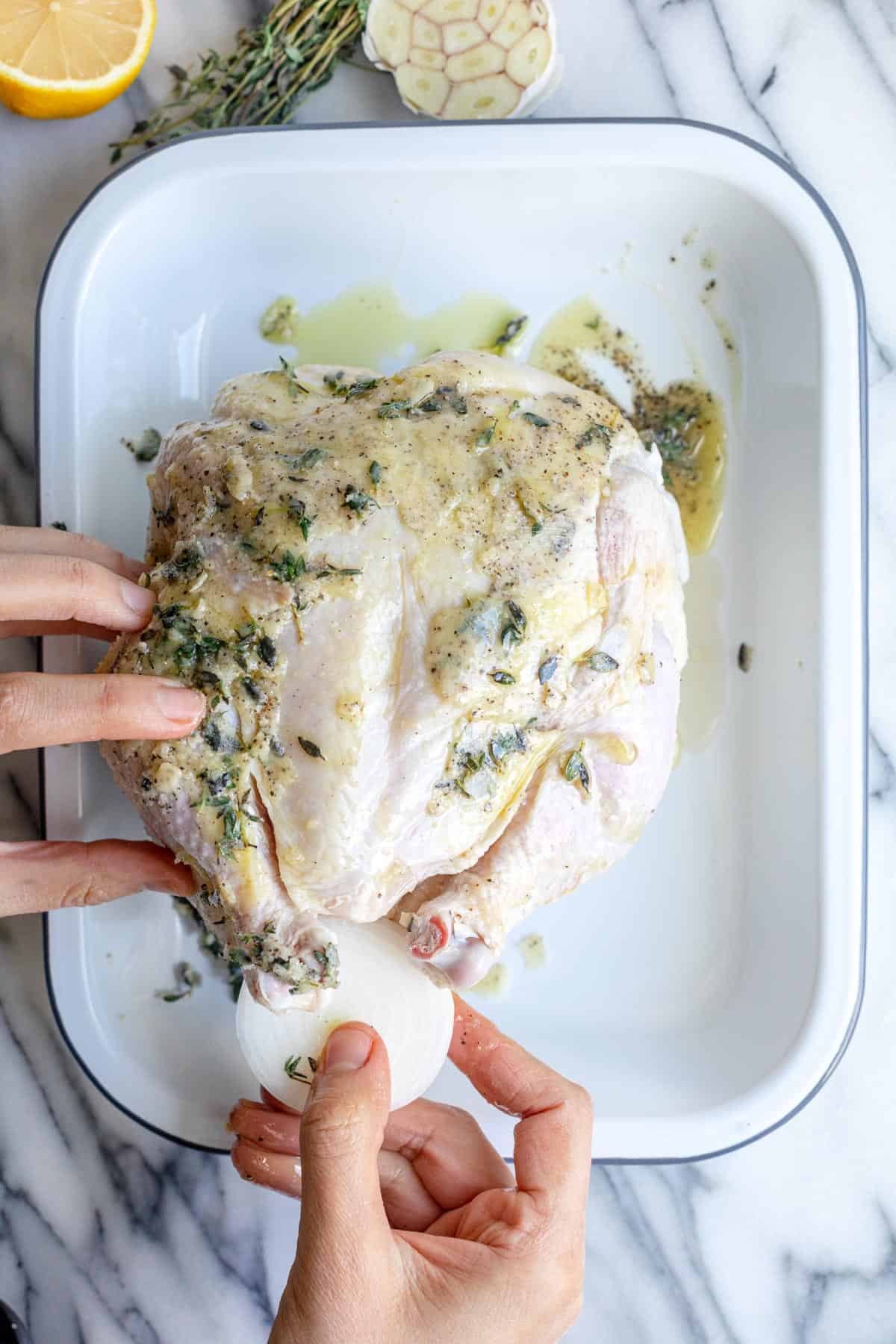 Stuffing onion inside chicken.