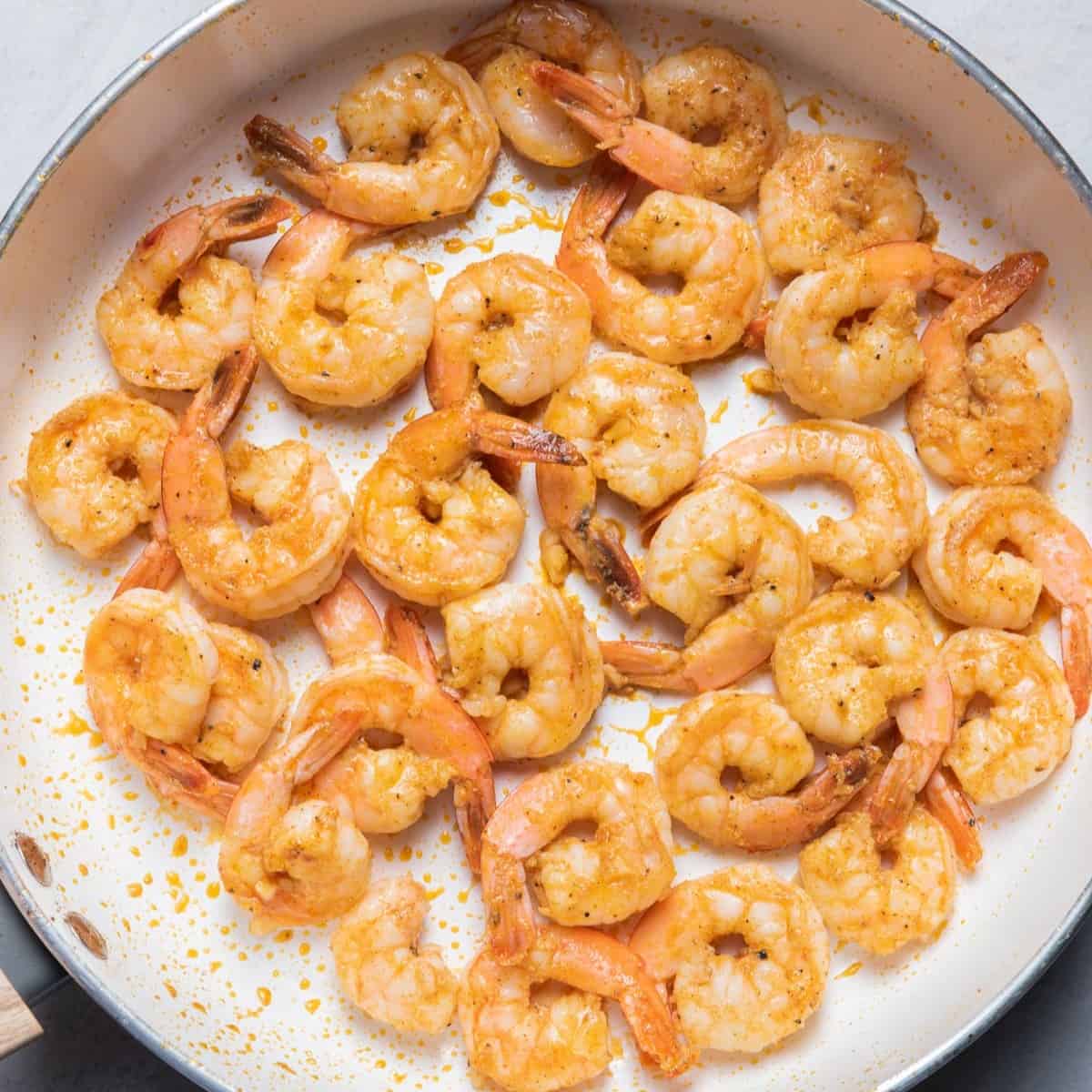 Seasoned shrimp in a skillet after cooking.