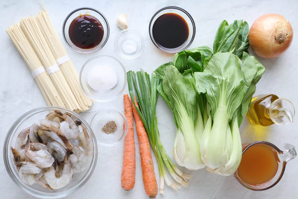 Ingredients for recipe: lo mein noodles, raw shrimp, oyster sauce, soy sauce, garlic, salt, sugar, pepper, carrots, green onions, bok choy, onion, oil, and broth.