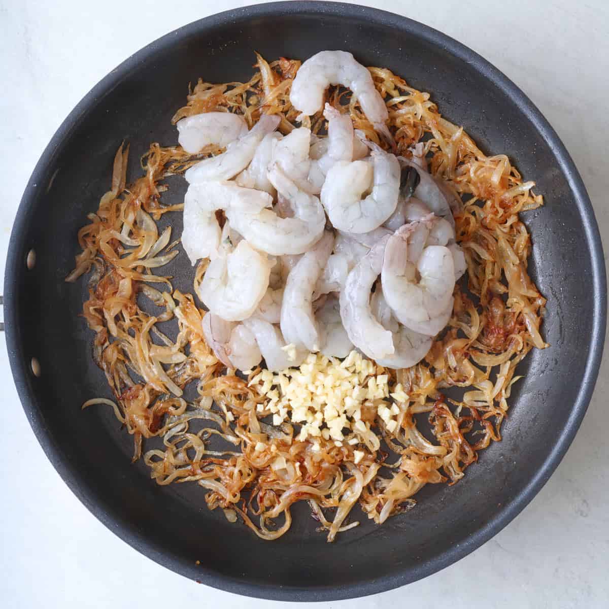 Shrimp and garlic added to onions before cooking.