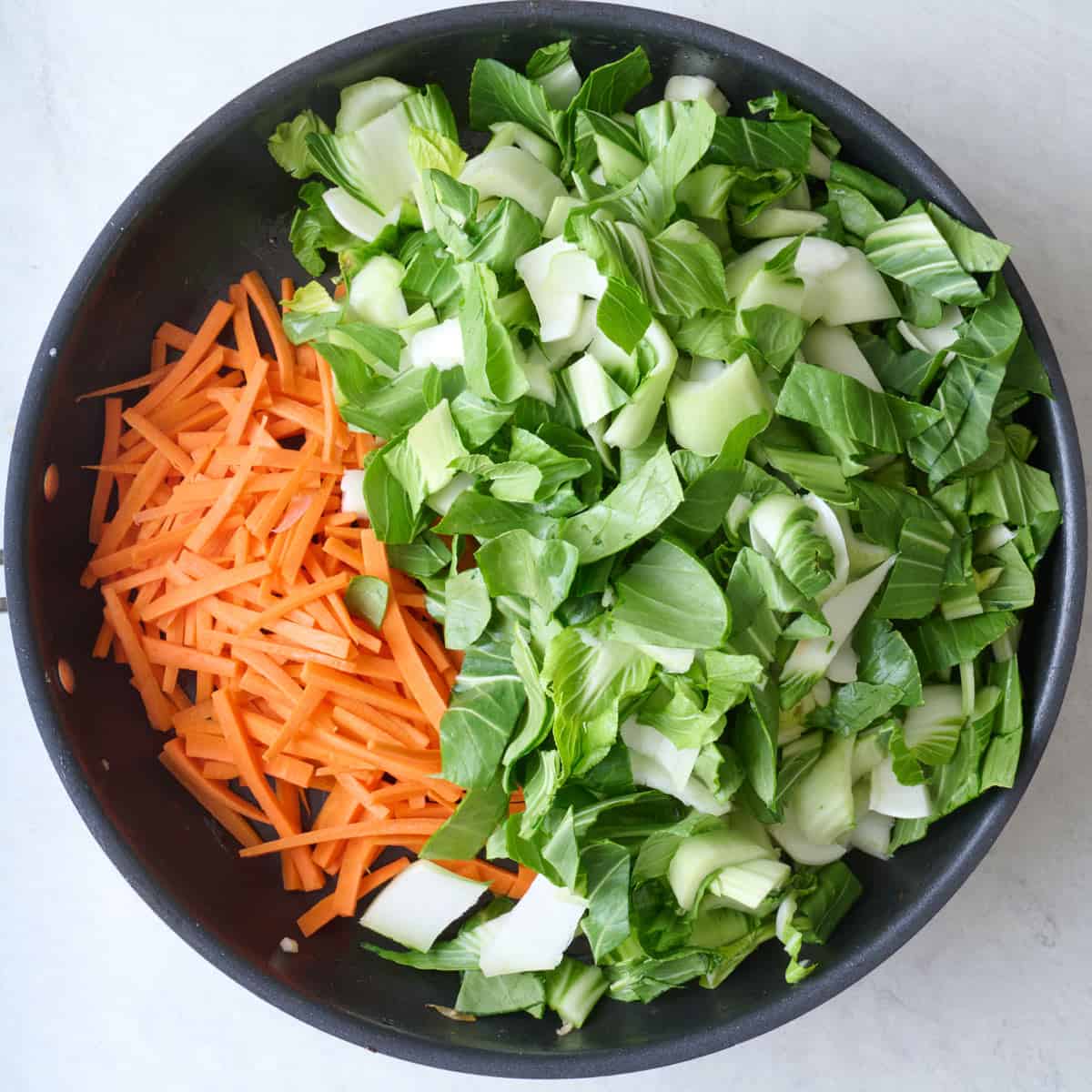 Bok choy and carrots added to skillet after removing the shrimp mixture.