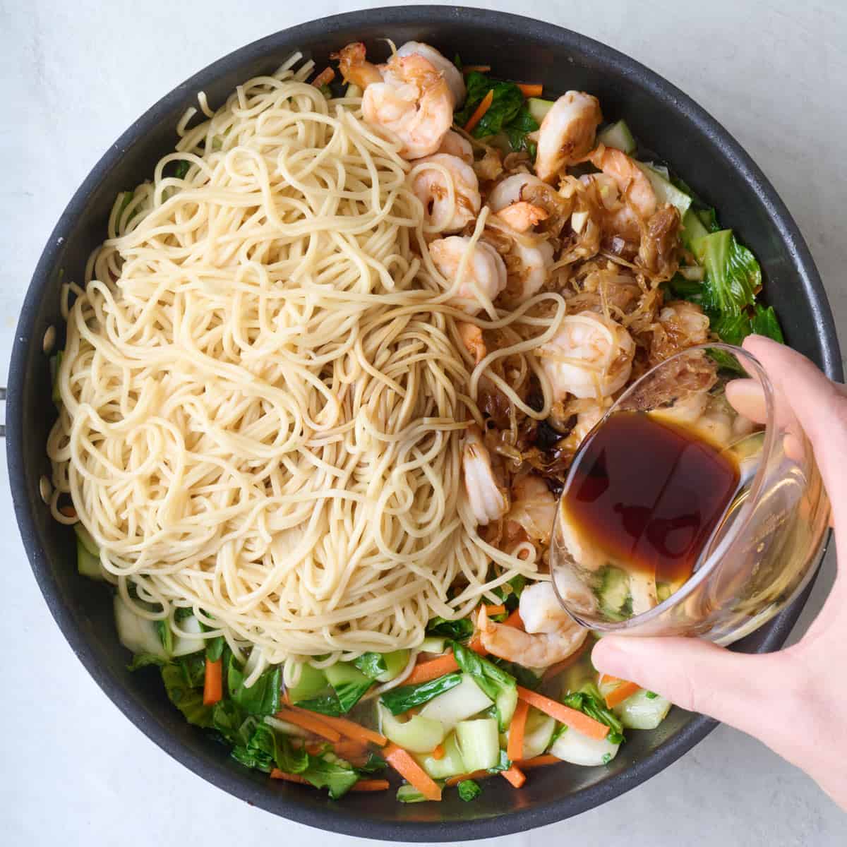 After veggies are crisp tender with cooked noodles, shrimp mixture and pouring in sauce.