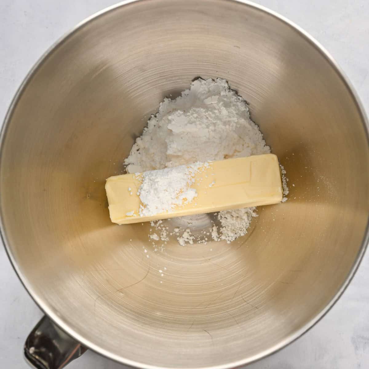 Butter and powdered sugar in the bowl of a stand mixer.