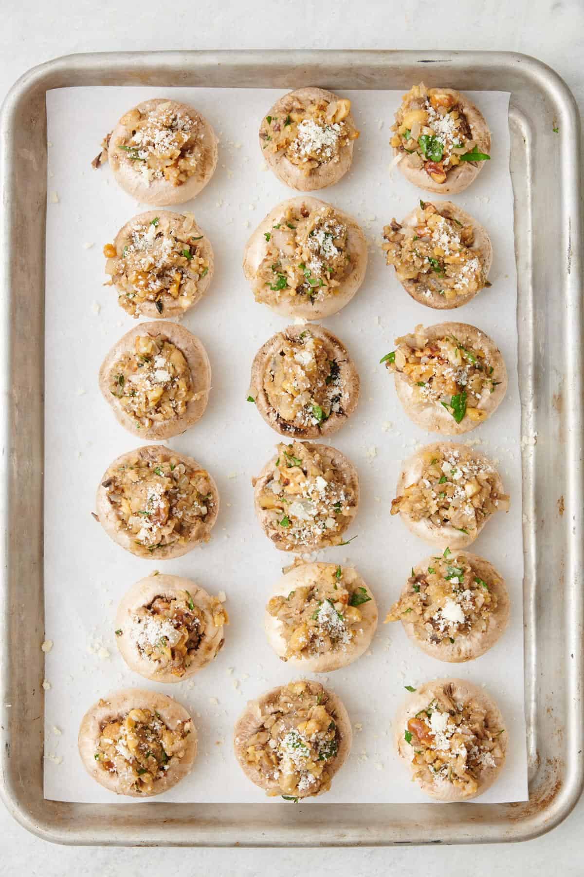 Mushroom caps filled with chickpeas mixture on a sheet pan.